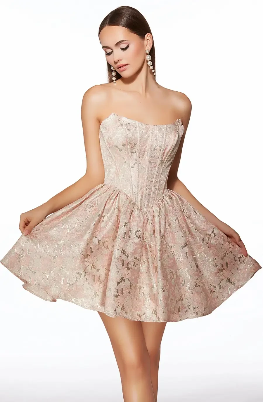 A model in a strapless, light pink dress with a flared skirt and intricate lace detailing.